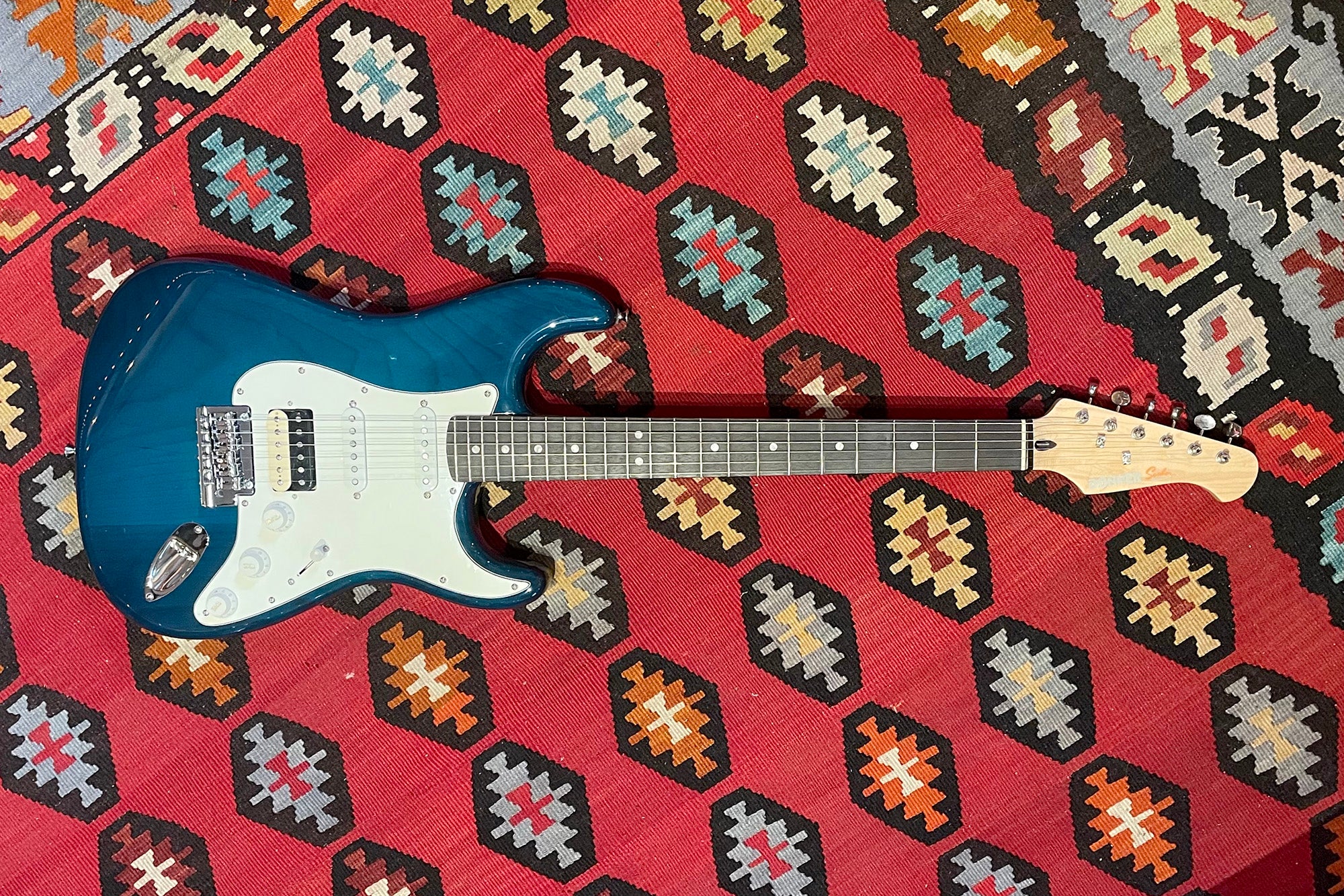 Blue Donner DST-400 budget electric guitar on a Southwestern rug