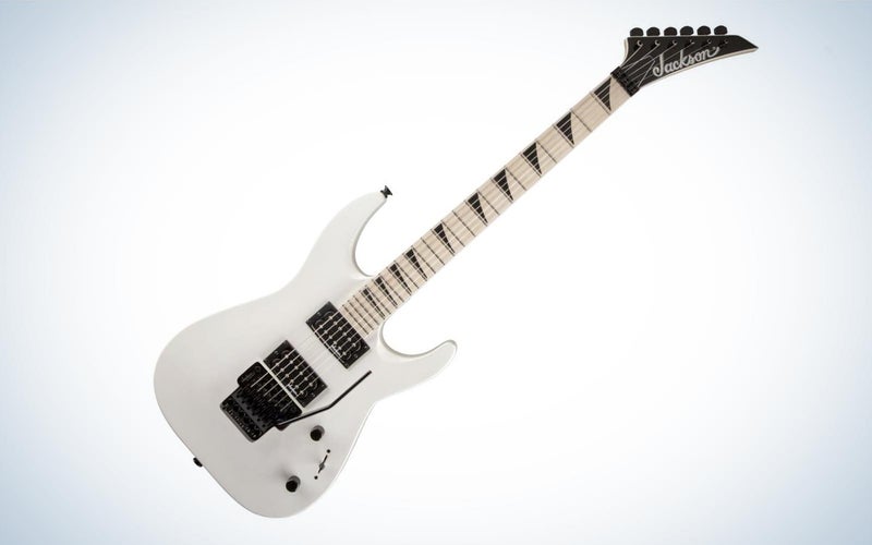 A white Jackson Dinky DKA M electric guitar tilted to the right on a plain background